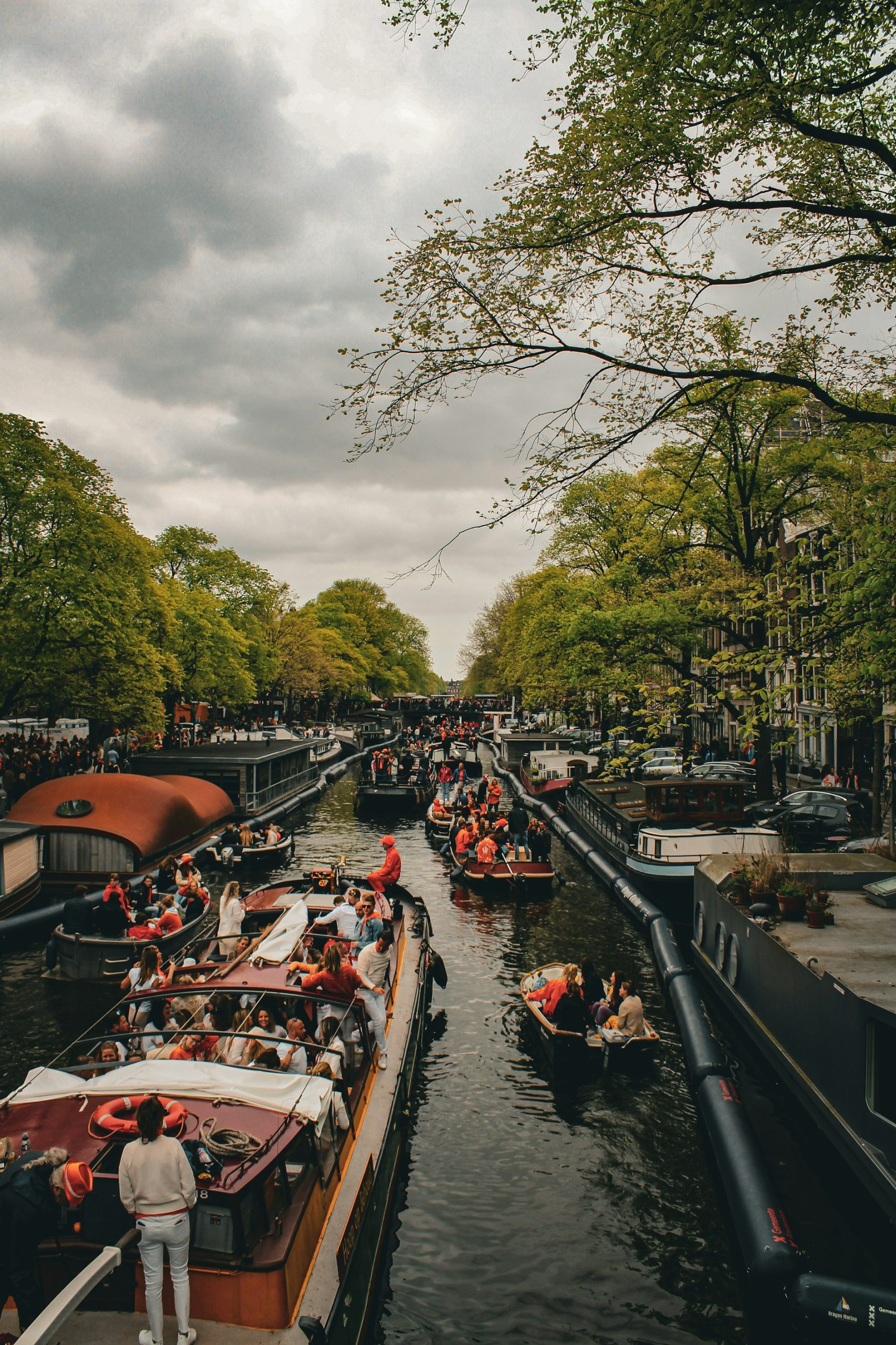 A View of boats in the canals during Amsterdam's King's Day.